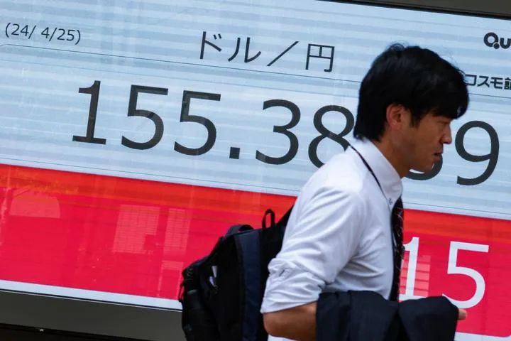 4月25日，行人走过日本东京一处显示实时汇率的电子屏幕。新华社记者张笑宇摄